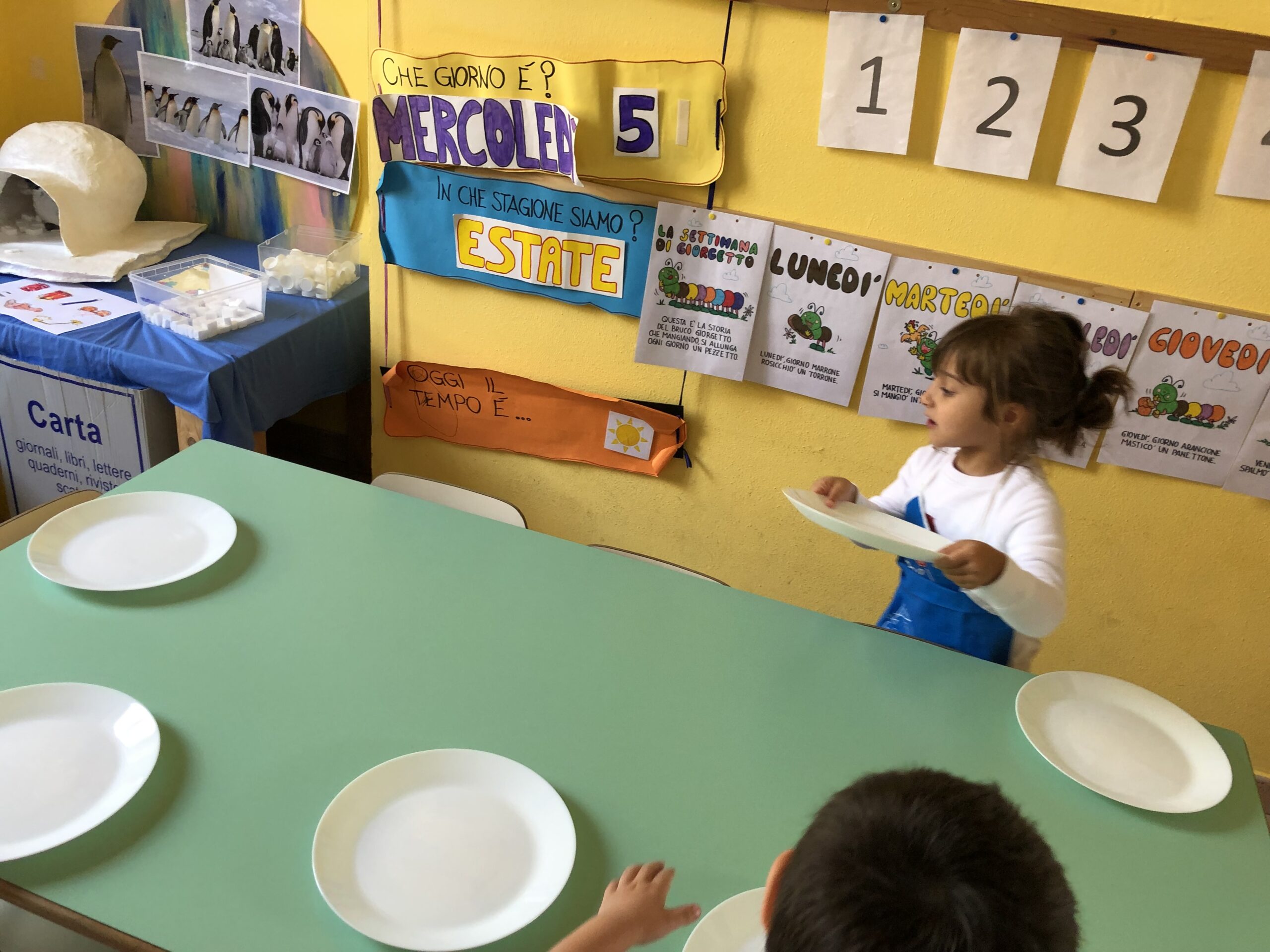 Una bambina prepara la tavola